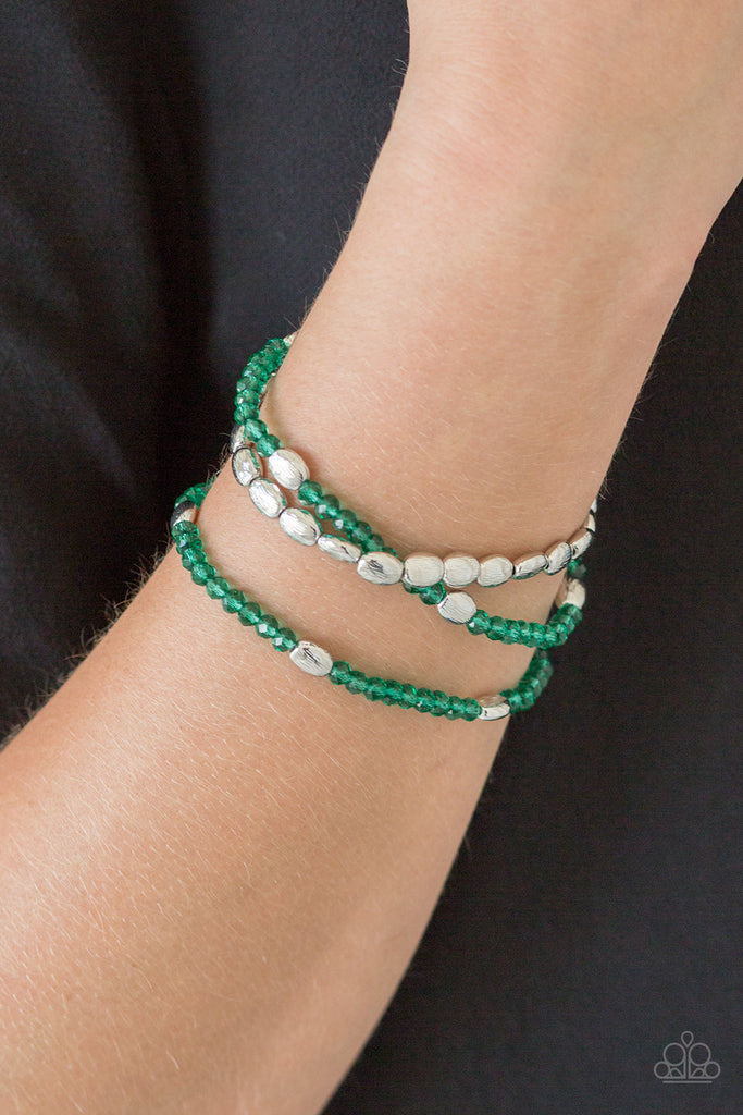 Infused with hints of silver, dainty green crystal-like beads are threaded along stretchy bands, creating whimsical layers across the wrist.  Sold as one set of three bracelets.