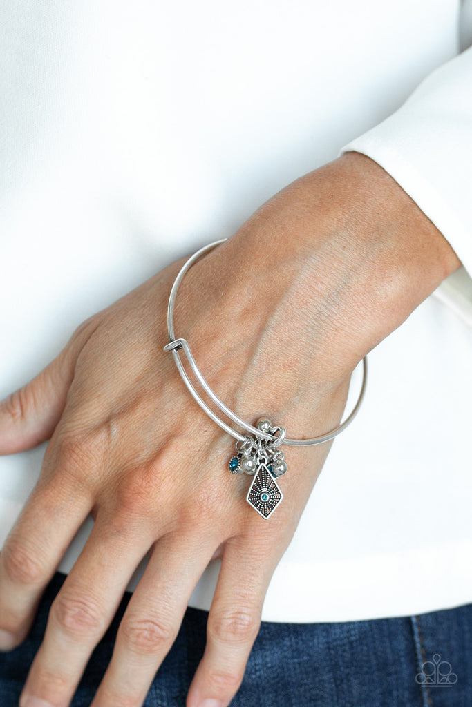 A collection of shimmery silver beads and glittery blue rhinestone accents slide along a sleek bar fitting, creating whimsical charms as they glide along the dainty silver bangle.  Sold as one individual bracelet.  