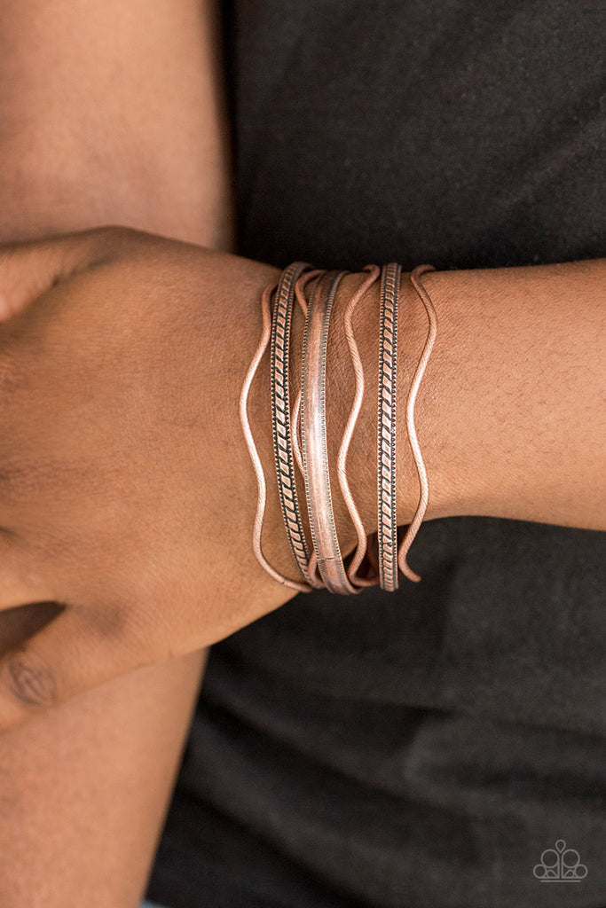 Stamped in tribal inspired patterns, round and wavy copper bangles stack across the wrist for a seasonal look.  Sold as one set of seven bracelets.  