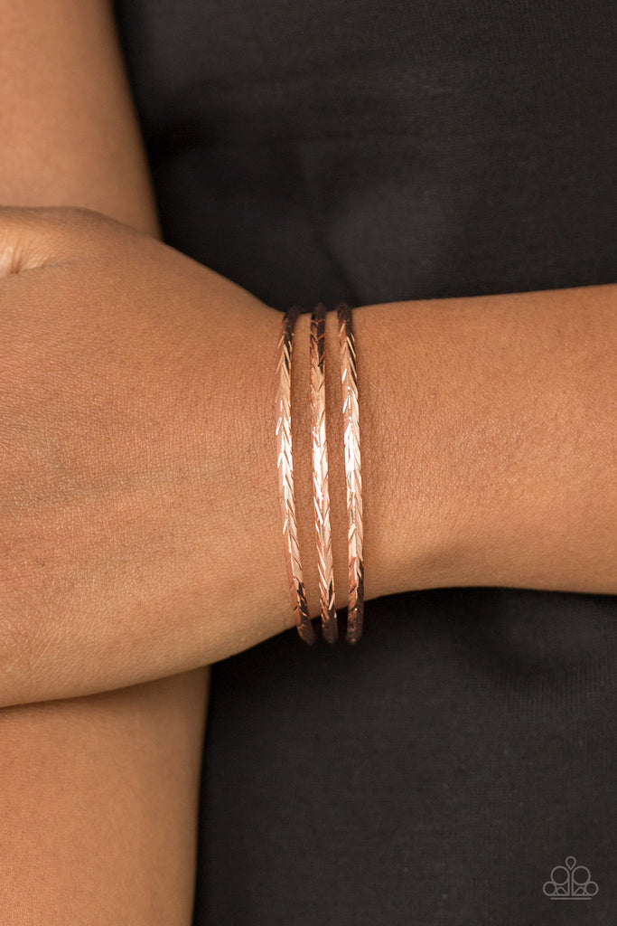 Etched in shimmery geometric patterns, shiny copper bars arc across the wrist, coalescing into a dainty cuff.  Sold as one individual bracelet.  