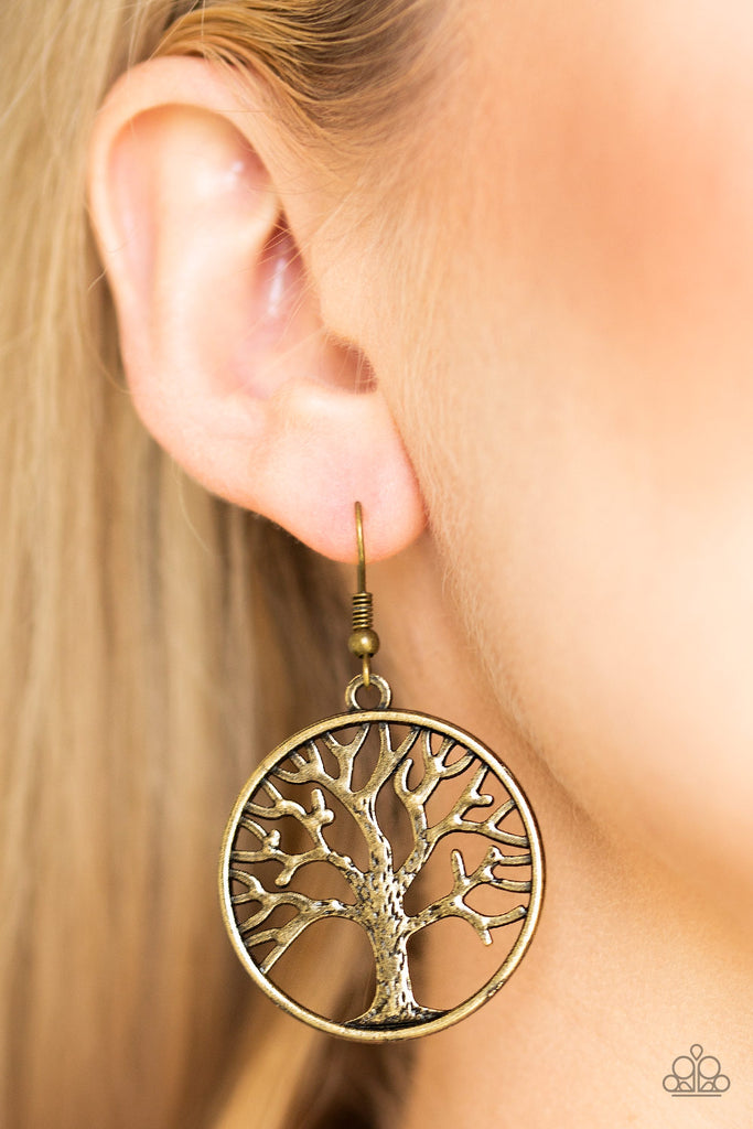 Brushed in an antiqued shimmer, a lifelike tree branches out across a brass hoop for a seasonal look. Earring attaches to a standard fishhook fitting.  Sold as one pair of earrings.