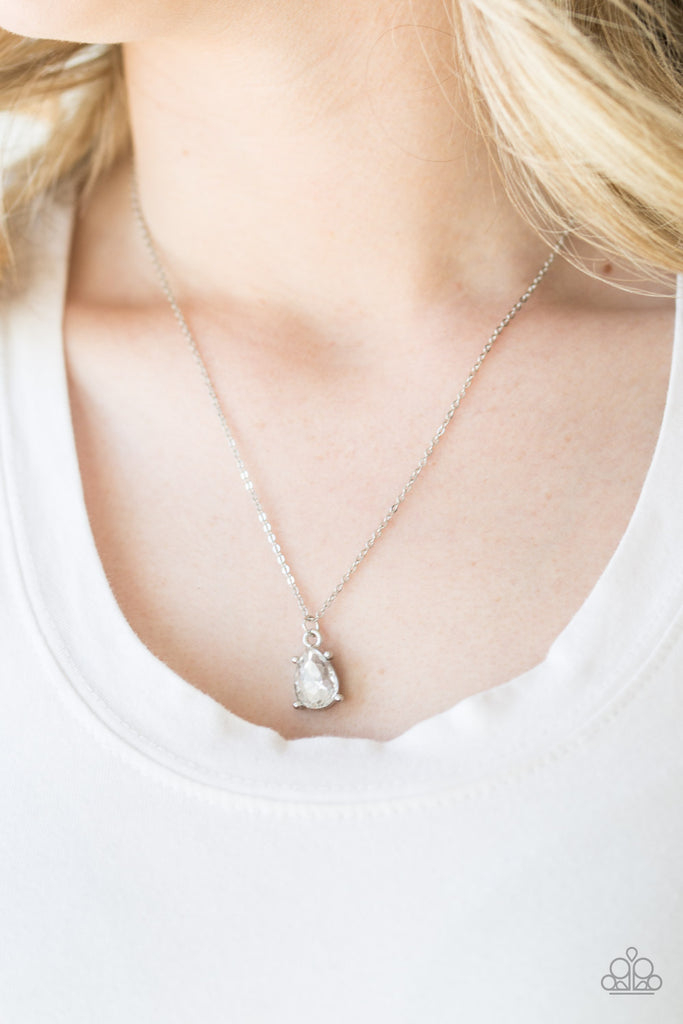 Featuring a regal teardrop cut, a glittery white gem swings from the bottom of a dainty silver chain, creating a timeless pendant below the collar. Features an adjustable clasp closure.  Sold as one individual necklace. Includes one pair of matching earrings.  