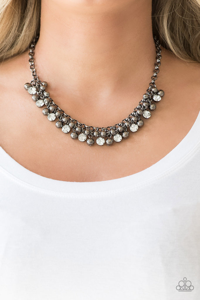 Classic gunmetal beads and oversized white rhinestones trickle from the bottom of interlocking gunmetal chains, creating a fierce fringe below the collar. Features an adjustable clasp closure.  Sold as one individual necklace. Includes one pair of matching earrings.