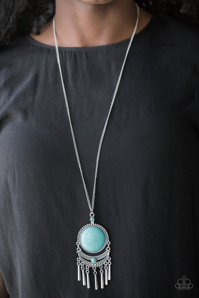 Swinging from the bottom of a lengthened silver chain, a dramatic turquoise stone gives way to an ornate crescent shaped frame dotted with a dainty turquoise stone. Brushed in an antiqued shimmer, flared silver bars swing from the bottom of the dramatic pendant, adding a playful movement to the seasonal palette. Features an adjustable clasp closure.  Sold as one individual necklace. Includes one pair of matching earrings.