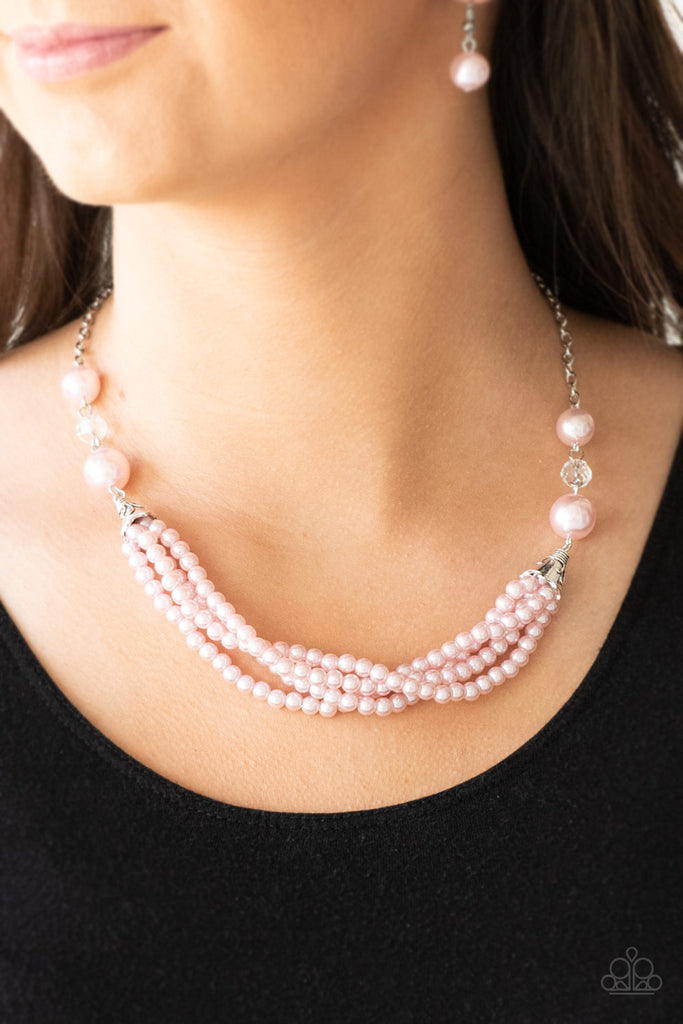 Oversized pink pearls and crystal-like beads give way to layers of beaded pearl strands below the collar for a timeless look. Features an adjustable clasp closure.  Sold as one individual necklace. Includes one pair of matching earrings.