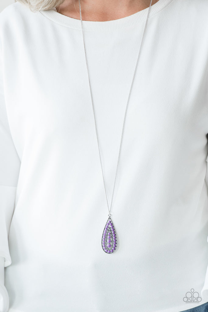 Brushed in a vivacious purple finish, a bubbly silver teardrop swings from the bottom of an elongated silver chain for a tribal inspired look. Features an adjustable clasp closure.  Sold as one individual necklace. Includes one pair of matching earrings.