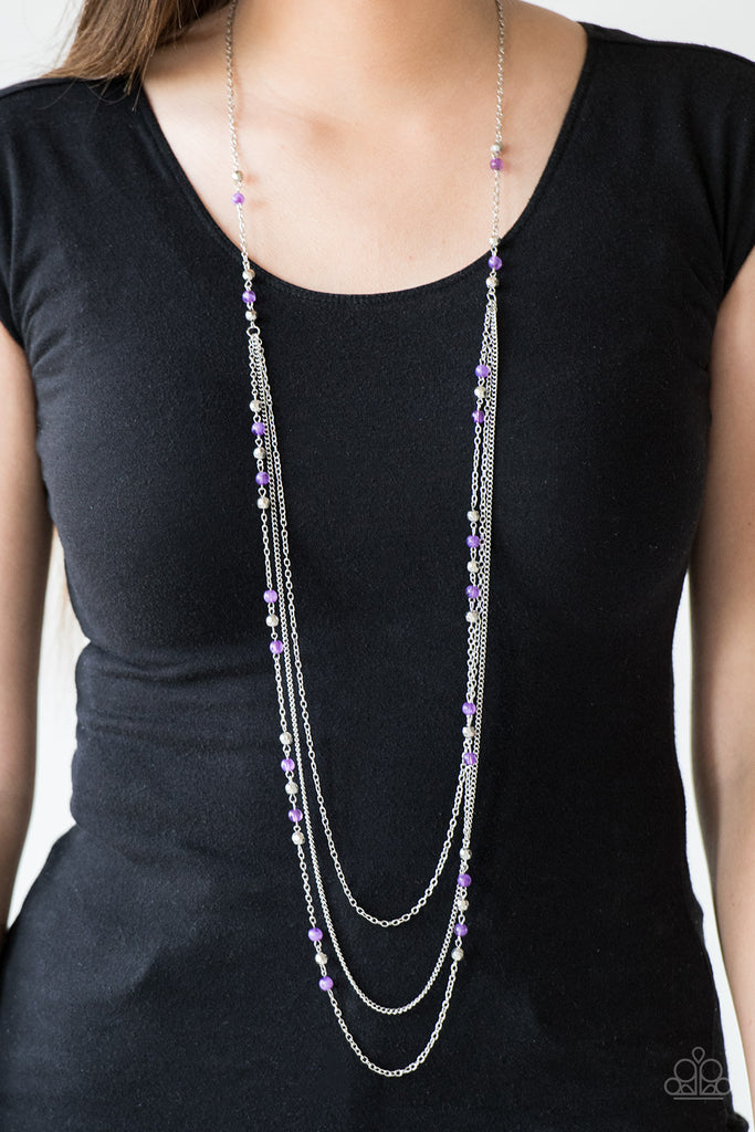 Faceted silver and glassy purple beads trickle along shimmery silver chains down the chest for a whimsical look. Features an adjustable clasp closure.  Sold as one individual necklace. Includes one pair of matching earrings.