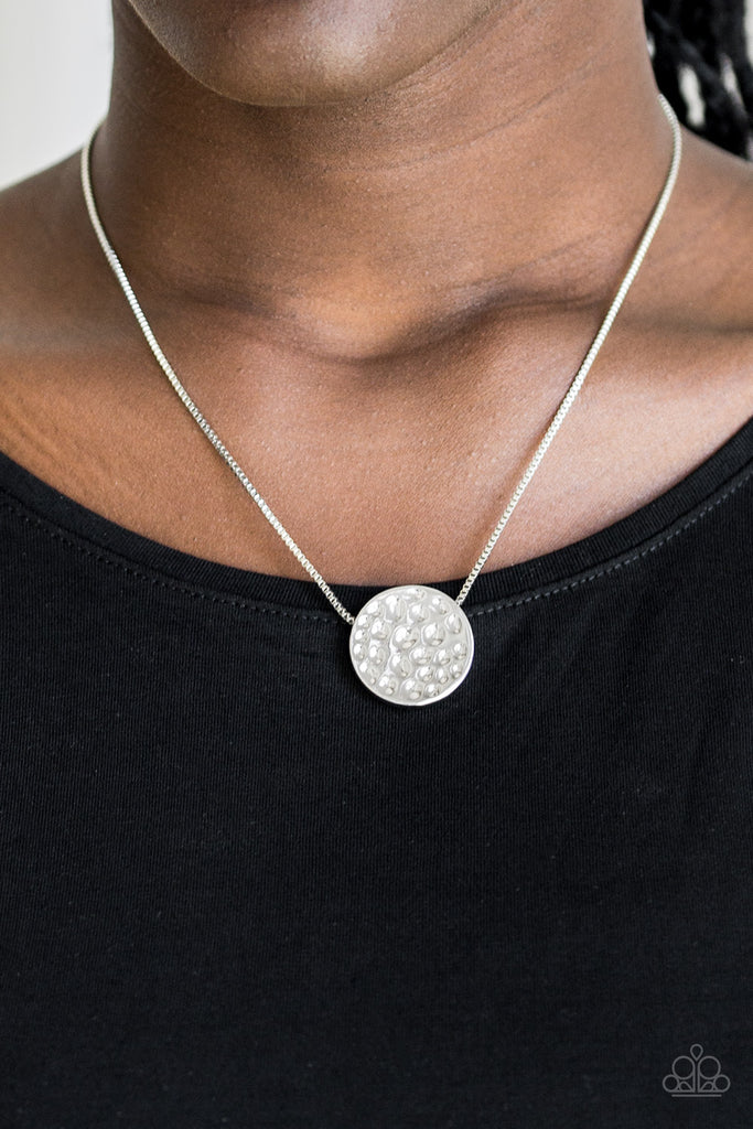 Delicately hammered in shimmery detail, a glistening silver pendant slides along a dainty silver box-chain below the collar for a bold look. Features an adjustable clasp closure.  Sold as one individual necklace. Includes one pair of matching earrings.  