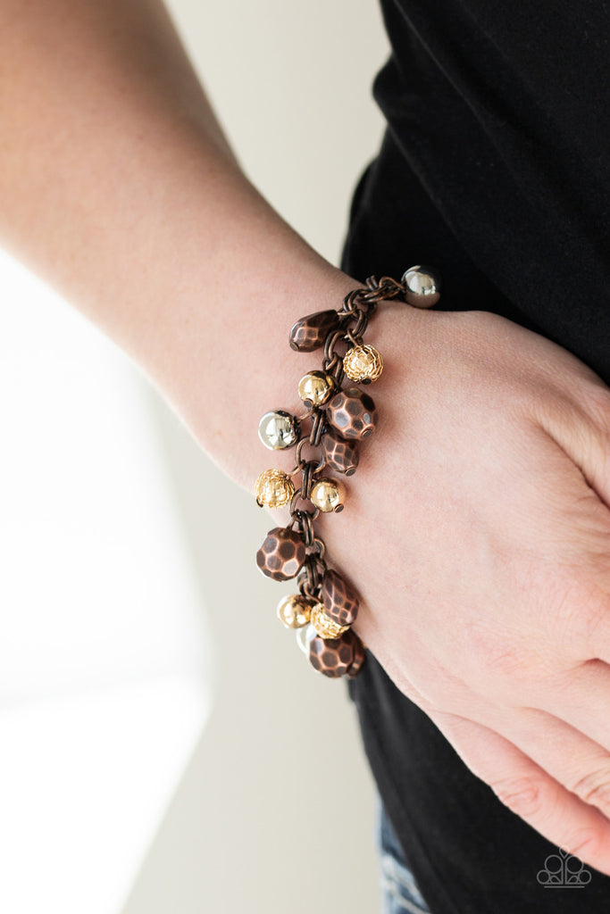 Featuring shiny, faceted, and mesh finishes, mismatched copper, gold, and silver beads trickle from the wrist for an edgy industrial look. Features an adjustable clasp closure.  Sold as one individual bracelet.