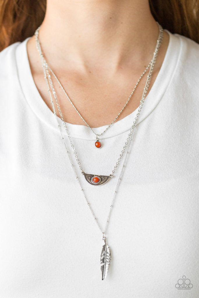 Featuring indigenous inspired pendants, mismatched silver chains layer down the chest for a seasonal look. Featuring robust orange beaded accents, dainty silver frames give way to a lifelike silver feather pendant for a free-spirited finish. Features an adjustable clasp closure.  Sold as one individual necklace. Includes one pair of matching earrings.  