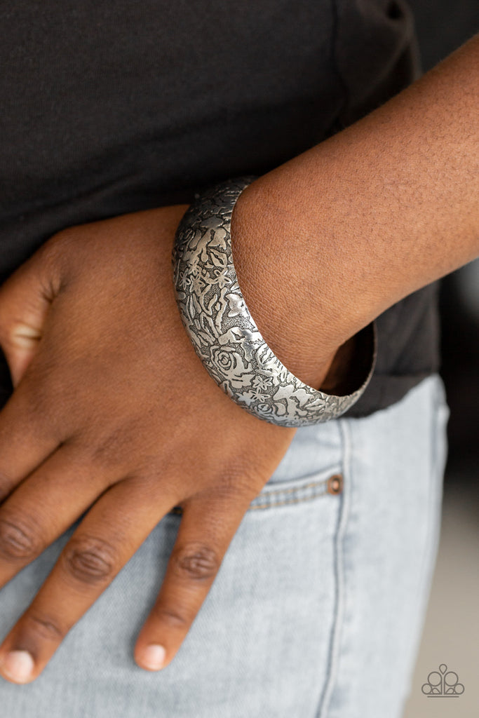 Brushed in an antiqued finish, a rosy floral pattern is embossed across a thick silver bangle for a seasonal flair.  Sold as one individual bracelet.  