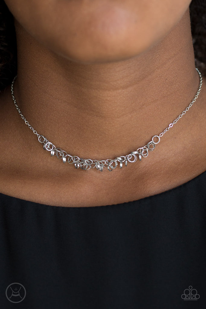 Dainty silver rings swing from a dainty silver chain, creating a flirtatious fringe. Features an adjustable clasp closure.  Sold as one individual choker necklace. Includes one pair of matching earrings.  Choker