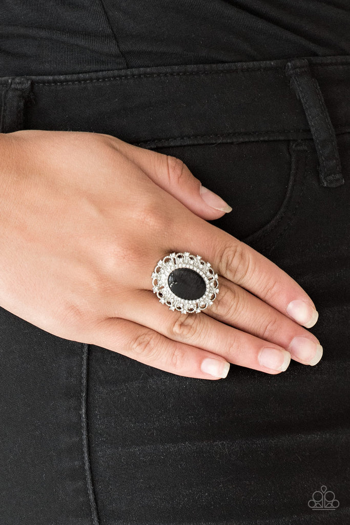 Encrusted in dainty white rhinestones, a frilly silver frame spins around a glowing black moonstone center for a regal look. Features a stretchy band for a flexible fit.  Sold as one individual ring.  