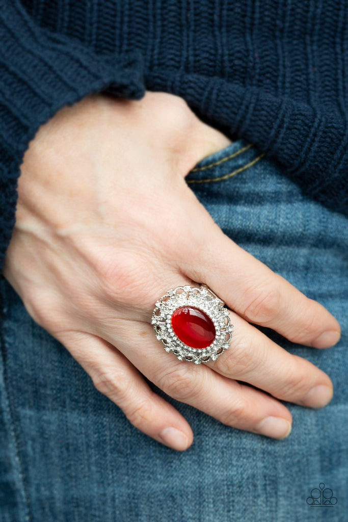 Encrusted in dainty white rhinestones, a frilly silver frame spins around a glowing red moonstone center for a regal look. Features a stretchy band for a flexible fit.  Sold as one individual ring.  
