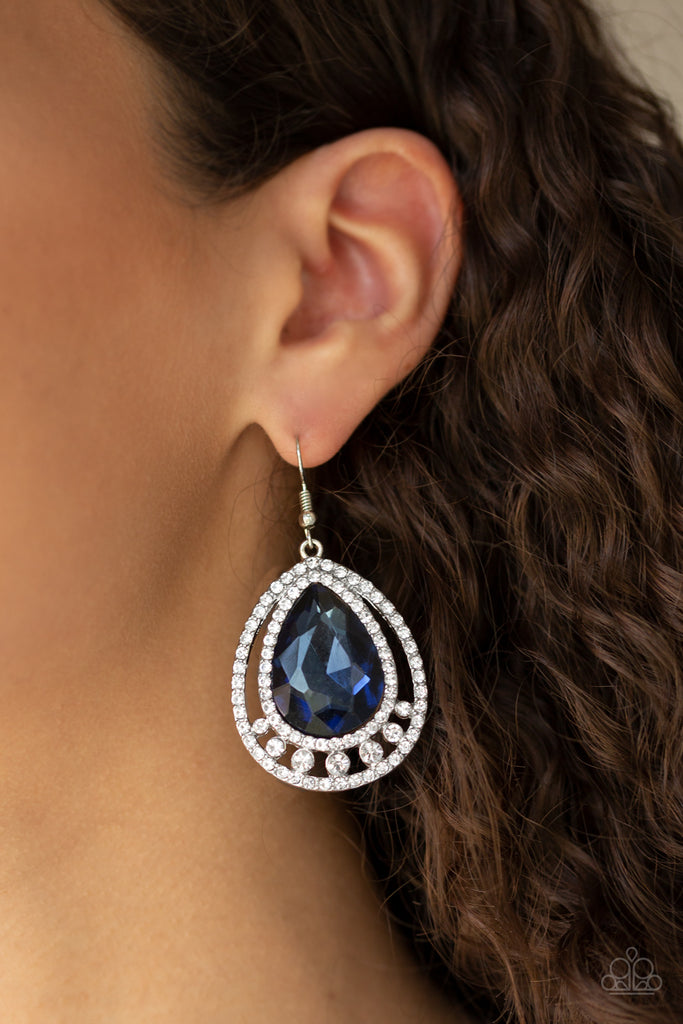 A dramatically oversized blue teardrop gem is nestled inside doubled silver frames radiating with glassy white rhinestones for a jaw-dropping style. Earring attaches to a standard fishhook fitting.  Sold as one pair of earrings.