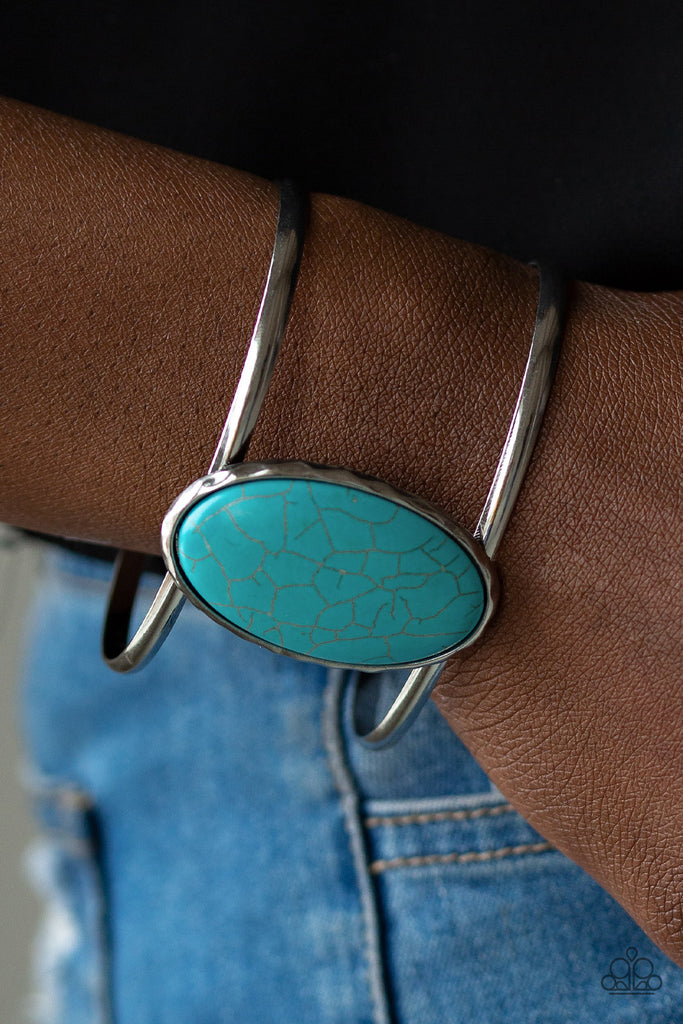 Chiseled into a tranquil oval, an oversized turquoise stone is pressed into the center of an airy silver cuff for a seasonal look.  Sold as one individual bracelet.