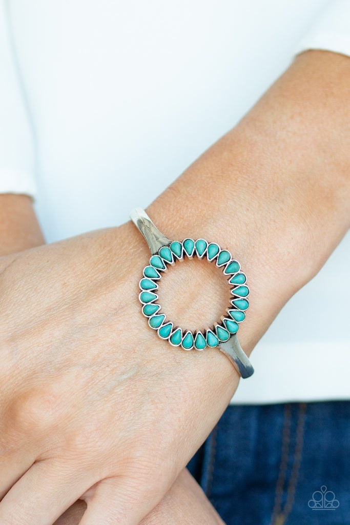 Chiseled into tranquil teardrops, earthy turquoise stones spin around the center of an antiqued silver cuff for a seasonal look.  Sold as one individual bracelet.