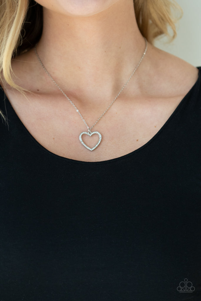 Encrusted in sparkly white rhinestones, an airy silver heart frame swings from a dainty silver chain below the collar for a romantic look. Features an adjustable clasp closure.  Sold as one individual necklace. Includes one pair of matching earrings.