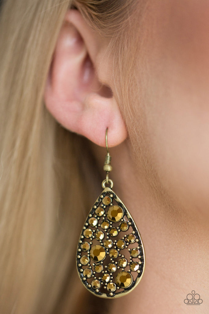 Varying in size, glittery aurum rhinestones are sprinkled along a studded brass teardrop for an edgy, yet glamorous look. Earring attaches to a standard fishhook fitting.  Sold as one pair of earrings.