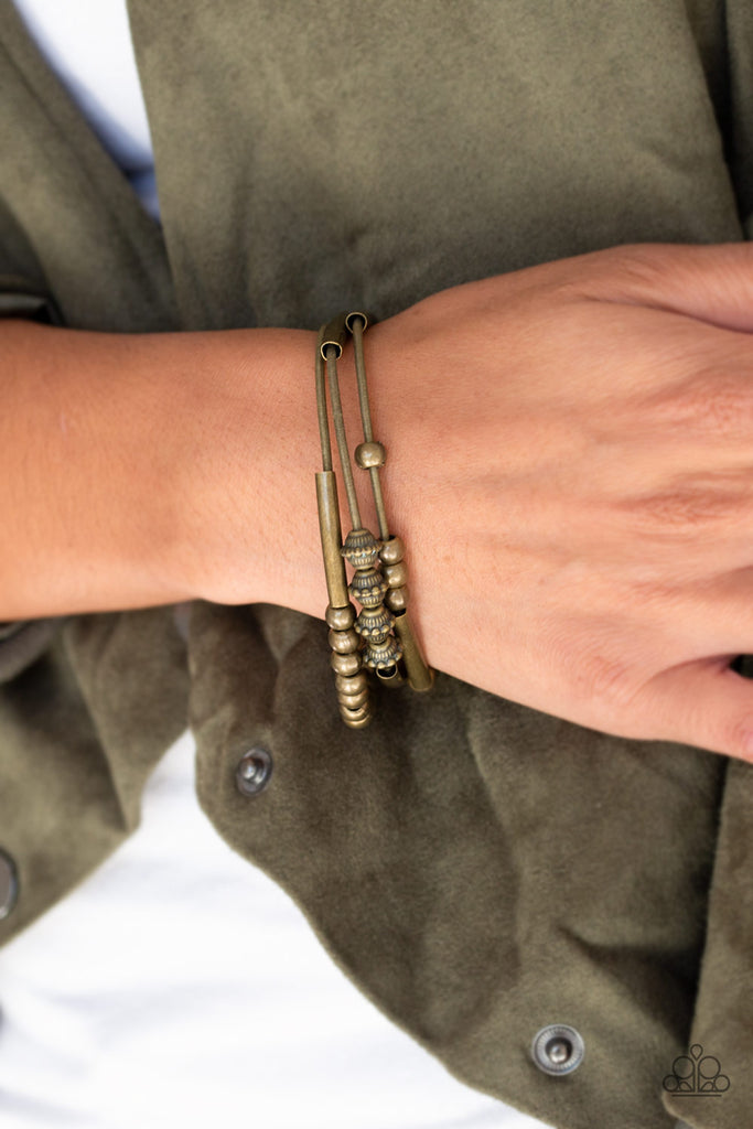 A collection of mismatched brass beads are threaded along three stretchy spring-like wires for a sleek industrial look.  Sold as one set of three bracelets.