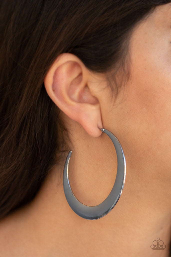 Brushed in a high-sheen finish, a flat gunmetal hoop curls into a bold crescent-like shape for an edgy look. Earring attaches to a standard post fitting. Hoop measures approximately 2 1/2" in diameter.  Sold as one pair of hoop earrings.