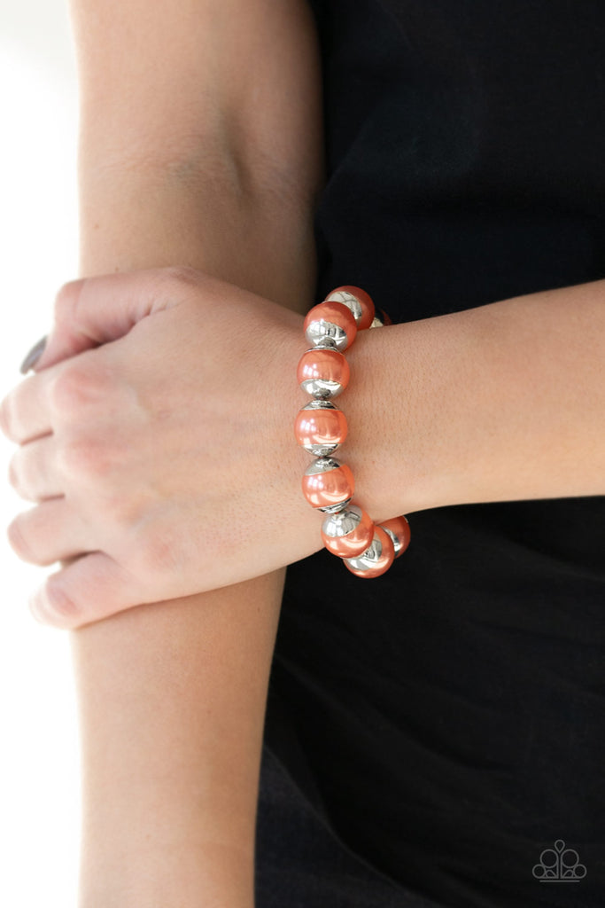 Capped in silver fittings, oversized orange pearls are threaded along a stretchy band around the wrist for a refined look.  Sold as one individual bracelet.