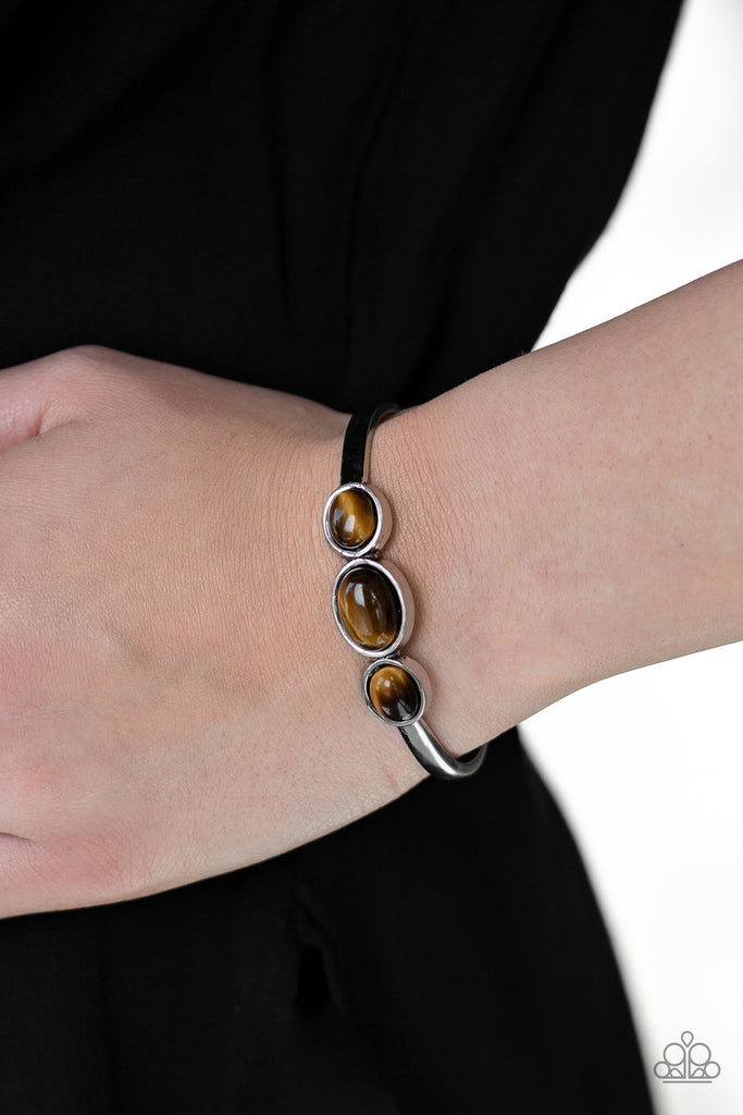 Glowing Tiger's Eye stones are encrusted across the middle of a dainty silver cuff for a seasonal flair. As the stone elements in this piece are natural, some color variation is normal.   Sold as one individual bracelet.  