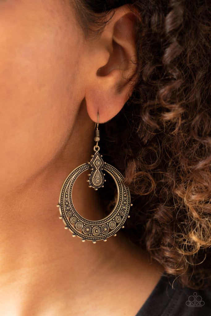 Featuring striped and floral patterns, dainty brass beads dot the bottom of a studded brass hoop that is attached to a matching ornate brass fitting for a tribal inspired look. Earring attaches to a standard fishhook fitting.  Sold as one pair of earrings.
