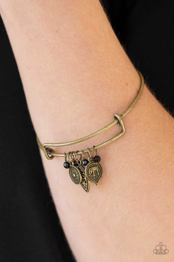 Dainty black beads and an array of brass charms featuring elephant and floral patterns slide along a sleek bar fitting for a whimsical look.  Sold as one individual bracelet.  