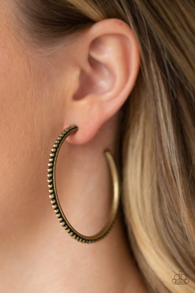 A studded brass hoop swings from the ear in a trendsetting fashion. Earring attaches to a standard post fitting. Hoop measures 2" in diameter.  Sold as one pair of hoop earrings.