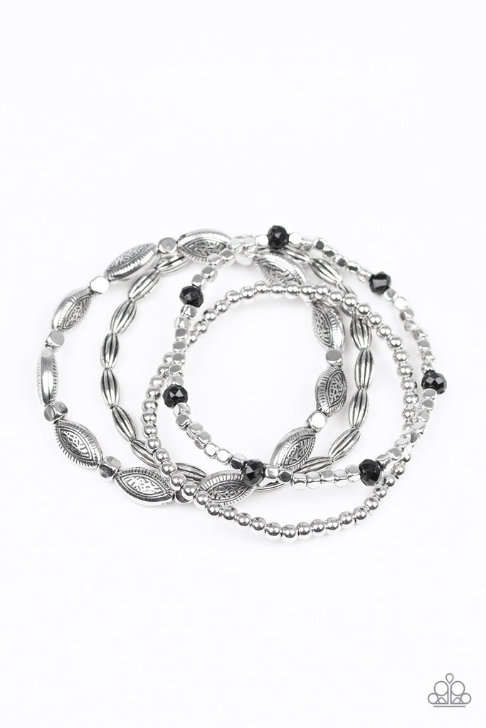 A collection of mismatched silver beads, silver cubes, and faceted black beads are threaded along four stretchy bands around the wrist for a colorful flair.  Sold as one set of four bracelets.