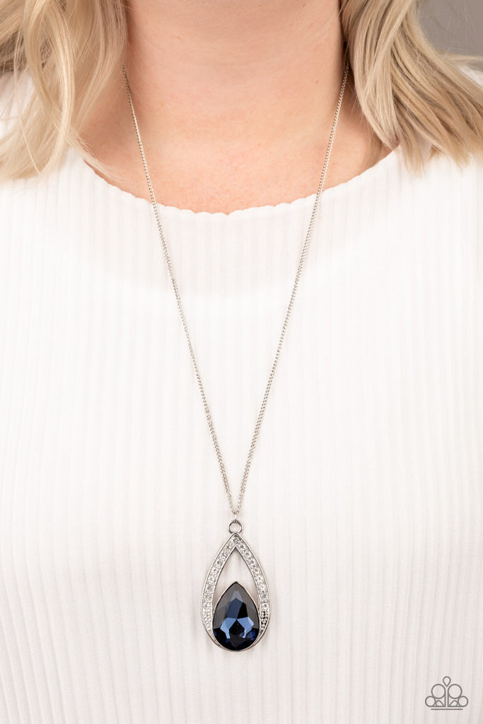 A glittery blue teardrop gem is pressed into a silver frame radiating with glassy white rhinestones. The glamorous pendant swings from the bottom of a shimmery silver chain for a refined look. Features an adjustable clasp closure.  Sold as one individual necklace. Includes one pair of matching earrings.  