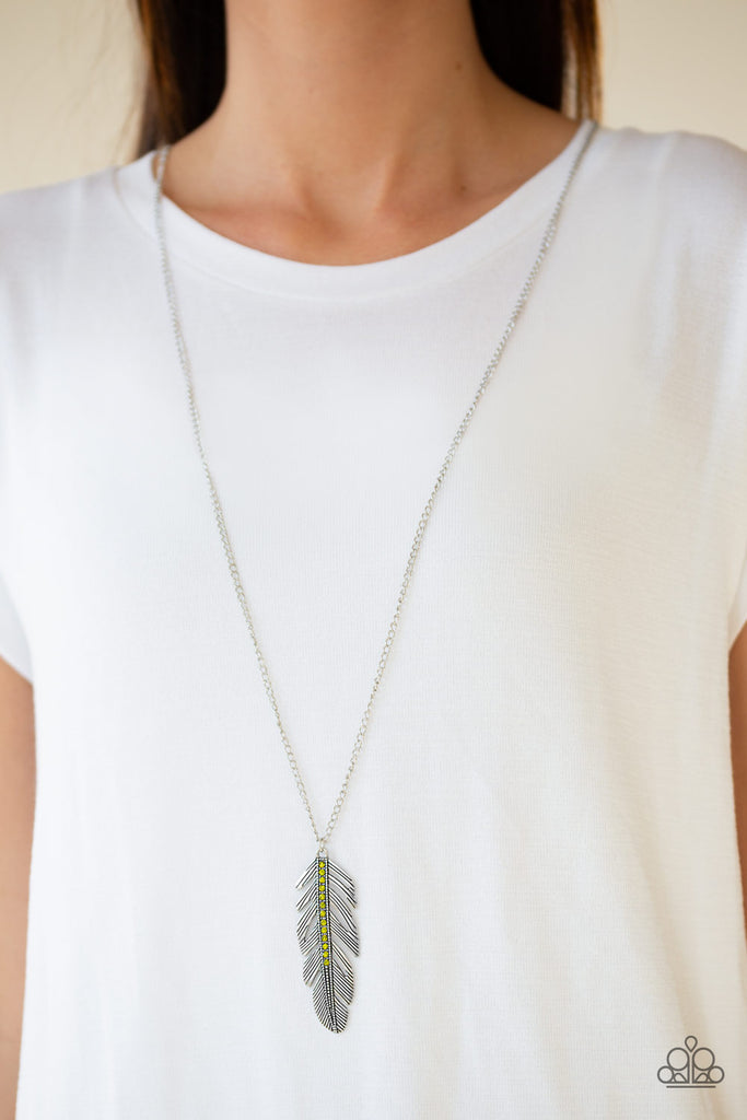 Glittery green rhinestones are encrusted down the spine of a life-like silver feather. The whimsical pendant swings from the bottom of a lengthened silver chain for a seasonal look. Features an adjustable clasp closure.  Sold as one individual necklace. Includes one pair of matching earrings.  