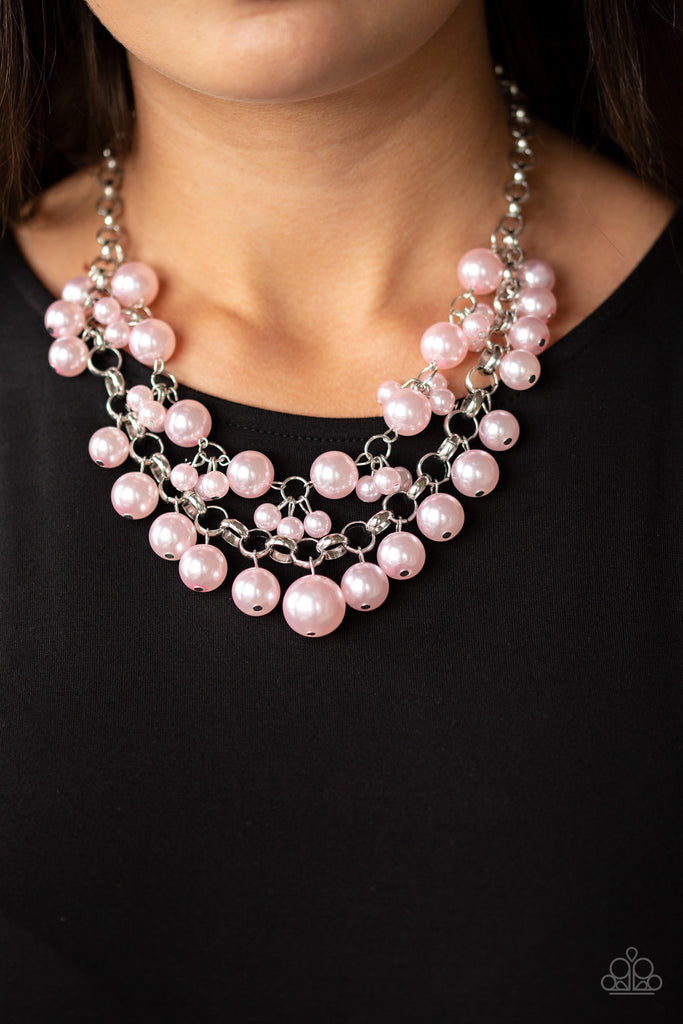 Two rows of mismatched pink pearls gorgeously drape below the collar. Featuring oversized silver links and an assortment of pearl sizes, the bubbly strands layer into a dramatic fringe for a modern timelessness. Features an adjustable clasp closure.  Sold as one individual necklace. Includes one pair of matching earrings.