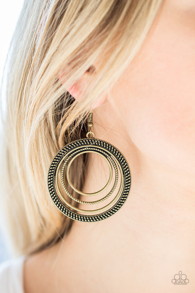 totally-textured-brass  Radiating with smooth, studded, and rope-like textures, mismatched brass hoops join into a rippling frame for a tribal inspired look. Earring attaches to a standard fishhook fitting.  Sold as one pair of earrings.