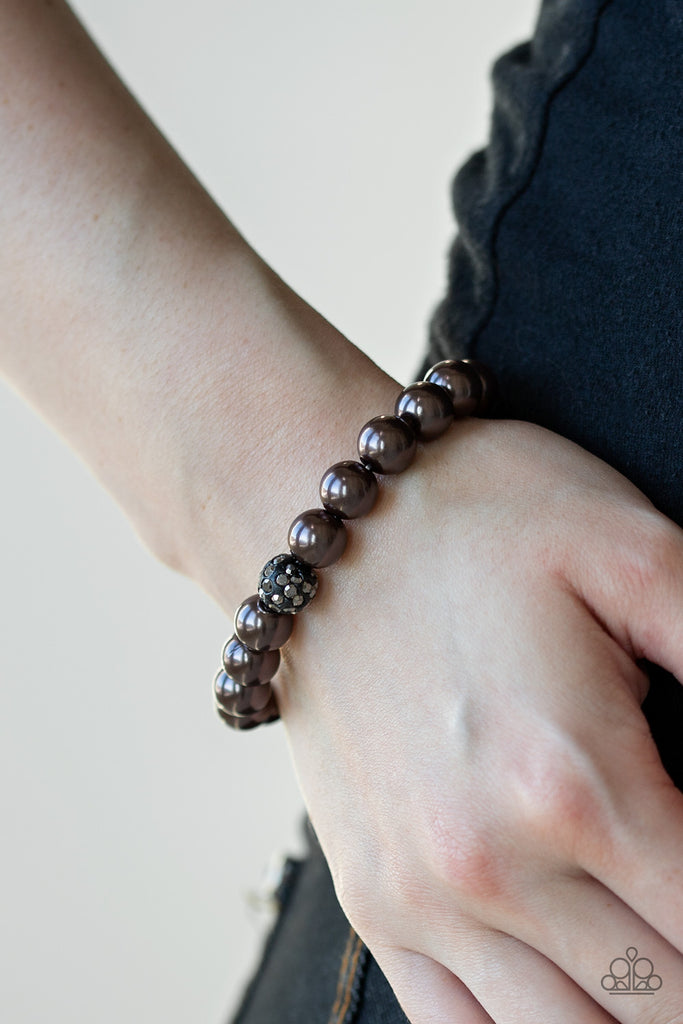 Infused with a glittery hematite rhinestone encrusted bead, a collection of pearly gunmetal beads are threaded along a stretchy band around the wrist for a glamorous look.  Sold as one individual bracelet.