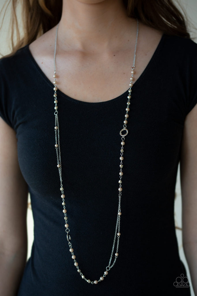 A collection of brown pearls, twisting silver hoops, and faceted silver beads trickle along an asymmetrical silver chain for a refined look. Features an adjustable clasp closure.  Sold as one individual necklace. Includes one pair of matching earrings.