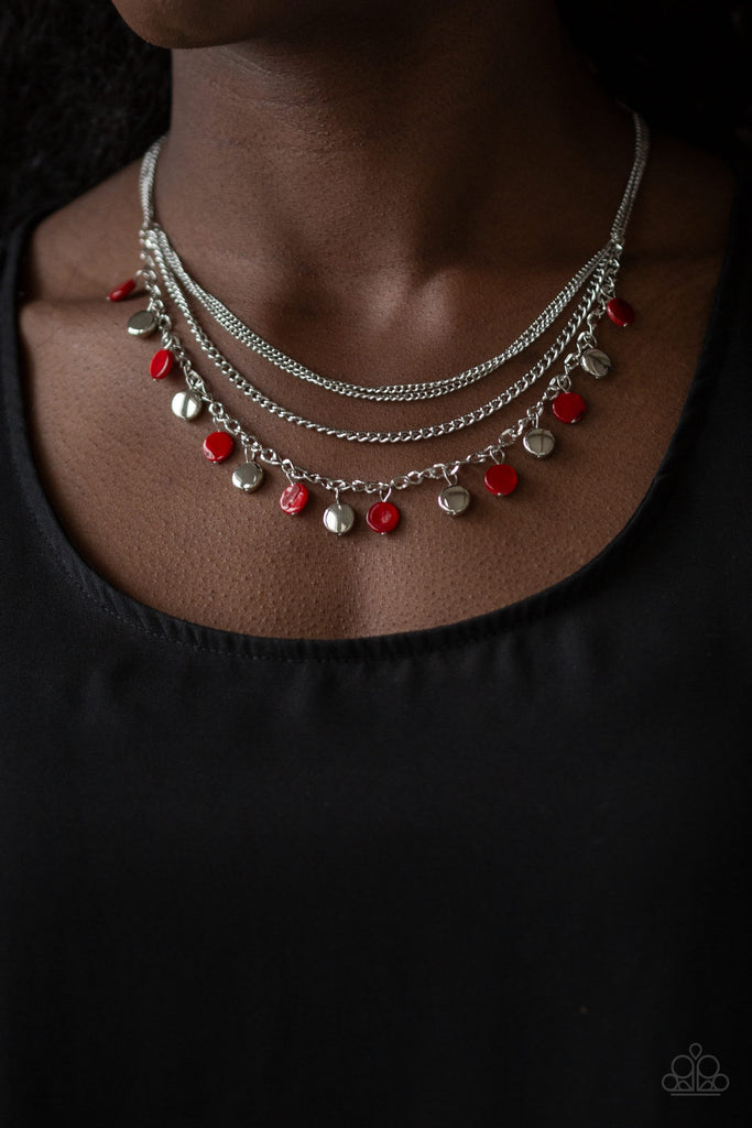 Mismatched silver chains layer below the collar. Shell-like red beads and shiny silver beads trickle from the lowermost chain, creating an iridescent fringe. Features an adjustable clasp closure.  Sold as one individual necklace. Includes one pair of matching earrings.