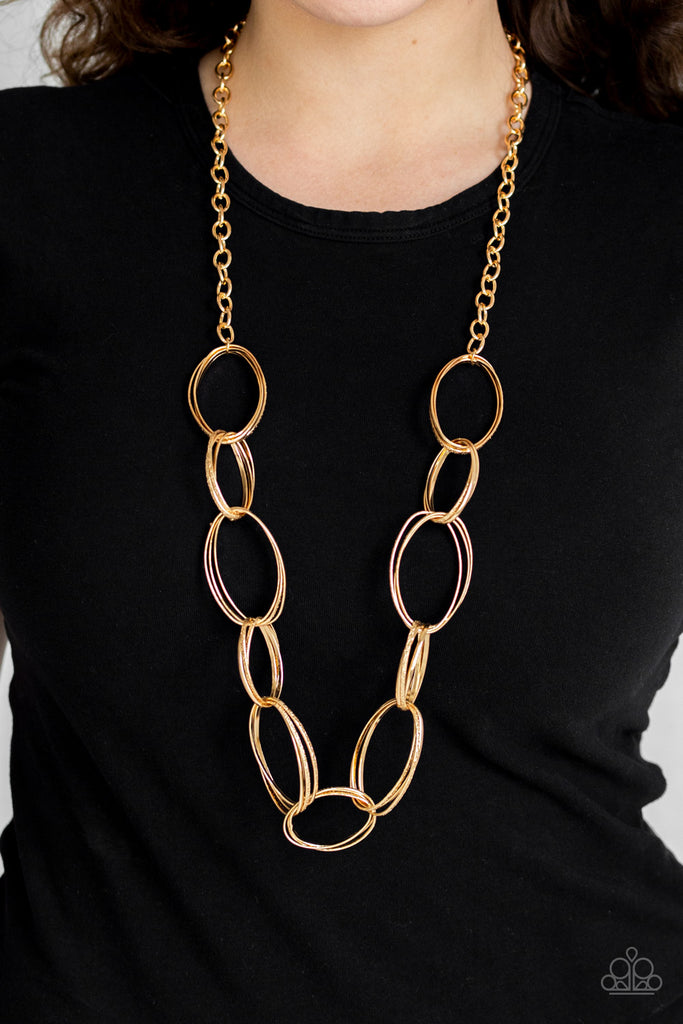 A collision of smooth and hammered gold oval links connect across the chest for a dramatic industrial look. Features an adjustable clasp closure.  Sold as one individual necklace. Includes one pair of matching earrings.  