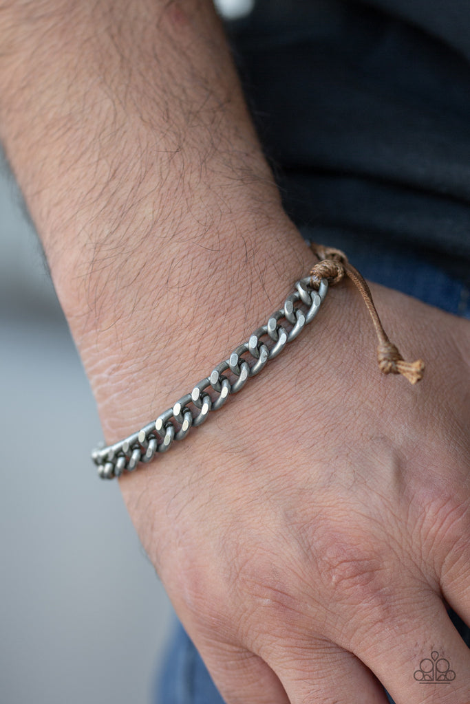 Shiny brown cording knots around the ends of a dainty silver beveled cable chain that is wrapped across the top of the wrist for a versatile look. Features an adjustable sliding knot closure.  Sold as one individual bracelet.  