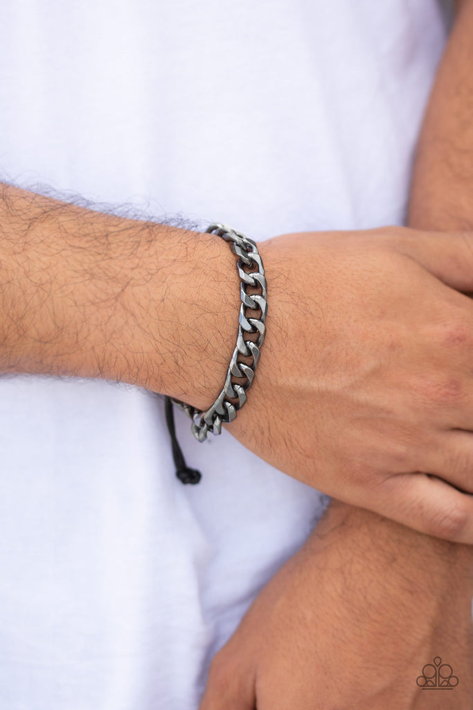 Shiny black cording knots around the ends of an ornate gunmetal beveled cable chain that is wrapped across the top of the wrist for a versatile look. Features an adjustable sliding knot closure.  Sold as one individual bracelet.