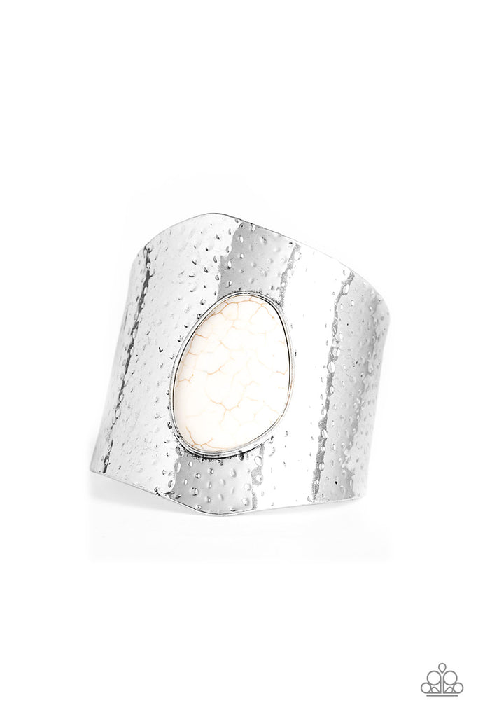 Delicately hammered in shimmery silver detail, a thick asymmetrical cuff wraps around the wrist. Chiseled into an abstract shape, a refreshing white stone is pressed into the center of the cuff for an artisan flair.  Sold as one individual bracelet.  