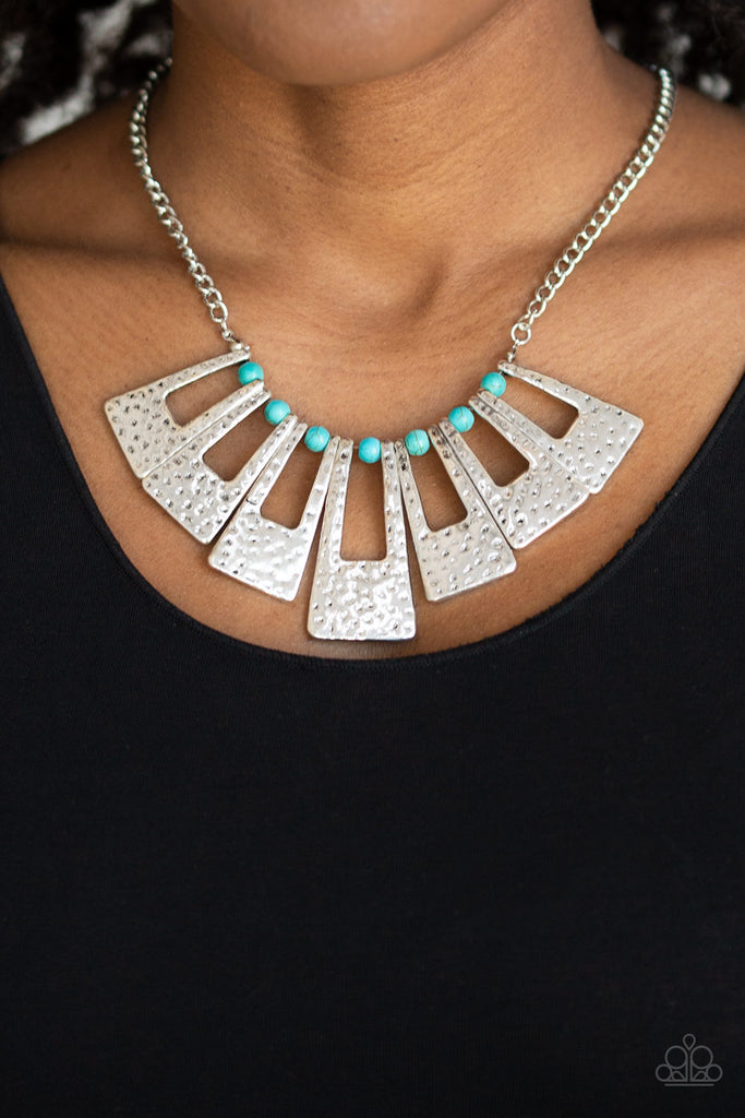 Infused with dainty turquoise stone beads, hammered silver rectangular frames fan about below the collar for a bold seasonal look. Features an adjustable clasp closure.  Sold as one individual necklace. Includes one pair of matching earrings.