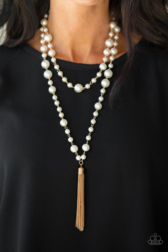A collection of bubbly white pearls link into two strands down the chest. A shimmery gold tassel swings from the lowermost strand, adding a timeless twist to the classic pearl palette. Features an adjustable clasp closure.  Sold as one individual necklace. Includes one pair of matching earrings.  