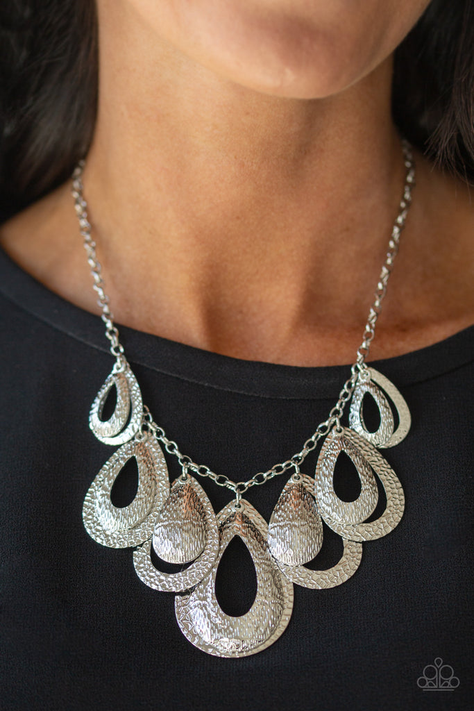 Hammered in a blinding textured finish, pairs of mismatched silver teardrops gradually increase in size as they drip below the collar, creating a statement-making fringe. Features an adjustable clasp closure.  Sold as one individual necklace. Includes one pair of matching earrings.
