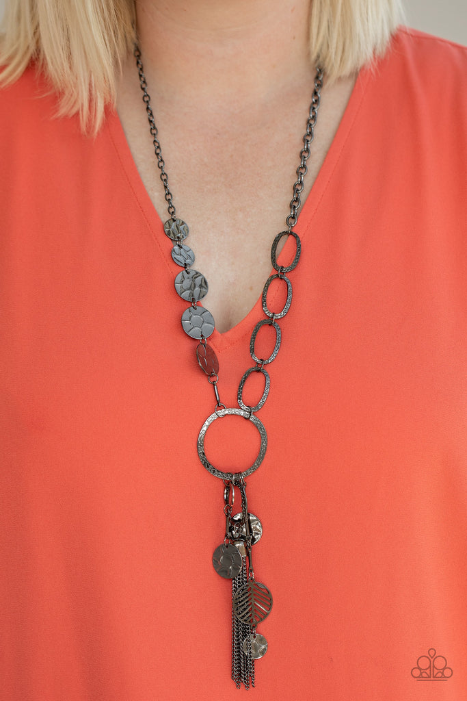 One row of hammered gunmetal discs and one row of hammered oval links give way to an oversized hammered gunmetal hoop. A collection of gunmetal discs, hammered links, abstract gunmetal pieces, and a shimmery gunmetal chain tassel dangles from the hoop, creating a one-of-a-kind pendant. Features an adjustable clasp closure.  Sold as one individual necklace. Includes one pair of matching earrings.