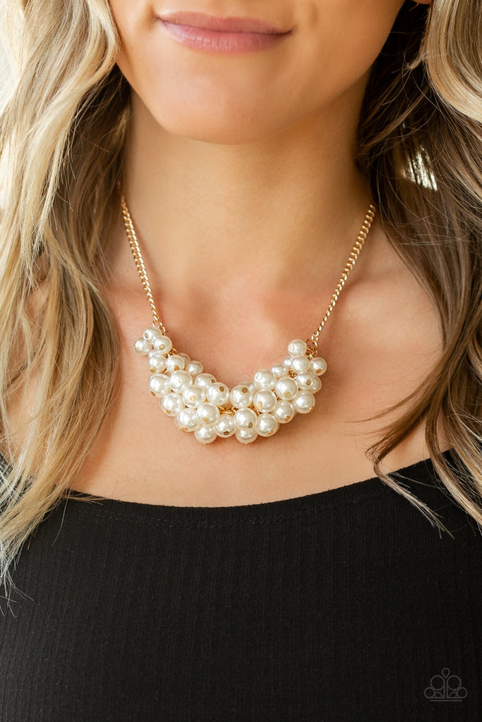 A collection of bubbly white pearls dangle from the bottom of a glistening gold chain, creating a glamorously clustered display below the collar. Features an adjustable clasp closure.  Sold as one individual necklace. Includes one pair of matching earrings.