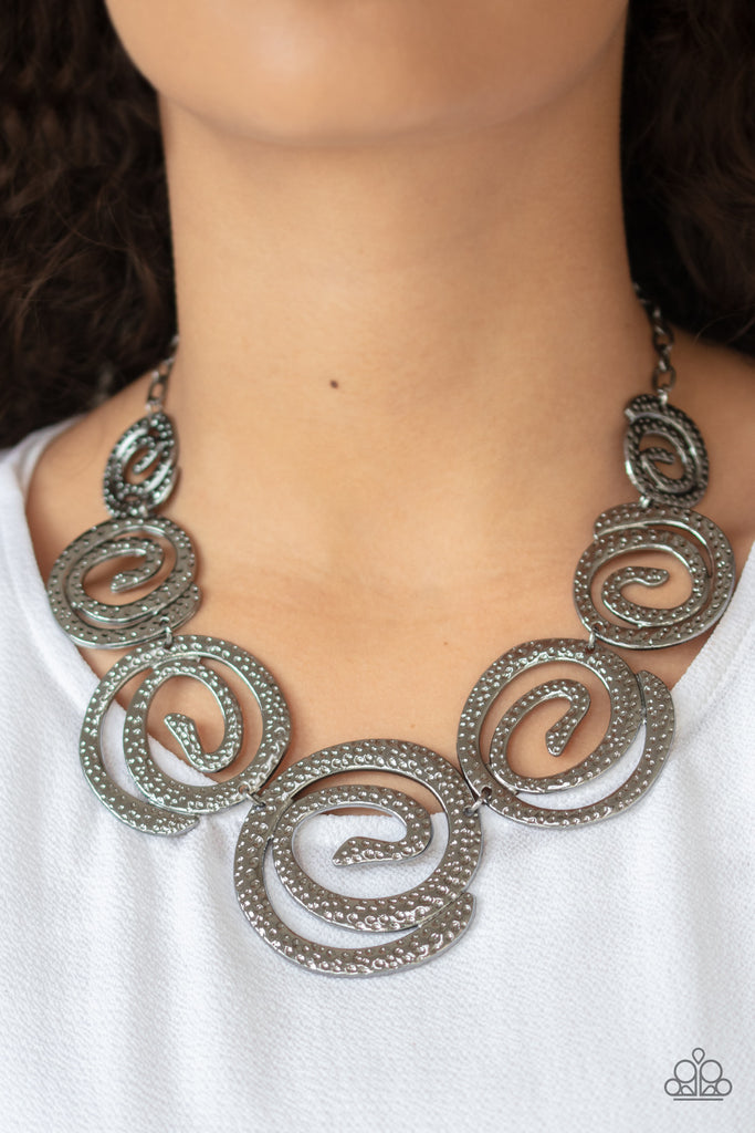 Gradually increasing in size, hammered gunmetal swirls link below the collar for a statement-making finish. Features an adjustable clasp closure.  Sold as one individual necklace. Includes one pair of matching earrings.
