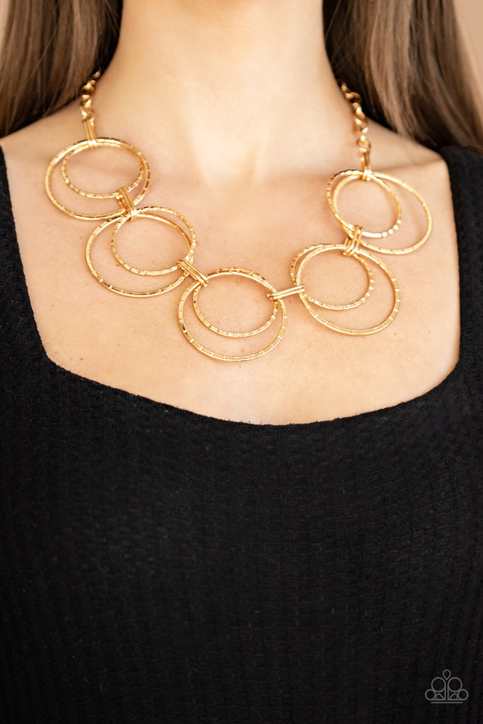 Etched in linear textures, pairs of oversized gold hoops link below the collar for a dramatic industrial display. Features an adjustable clasp closure.  Sold as one individual necklace. Includes one pair of matching earrings.  New Kit