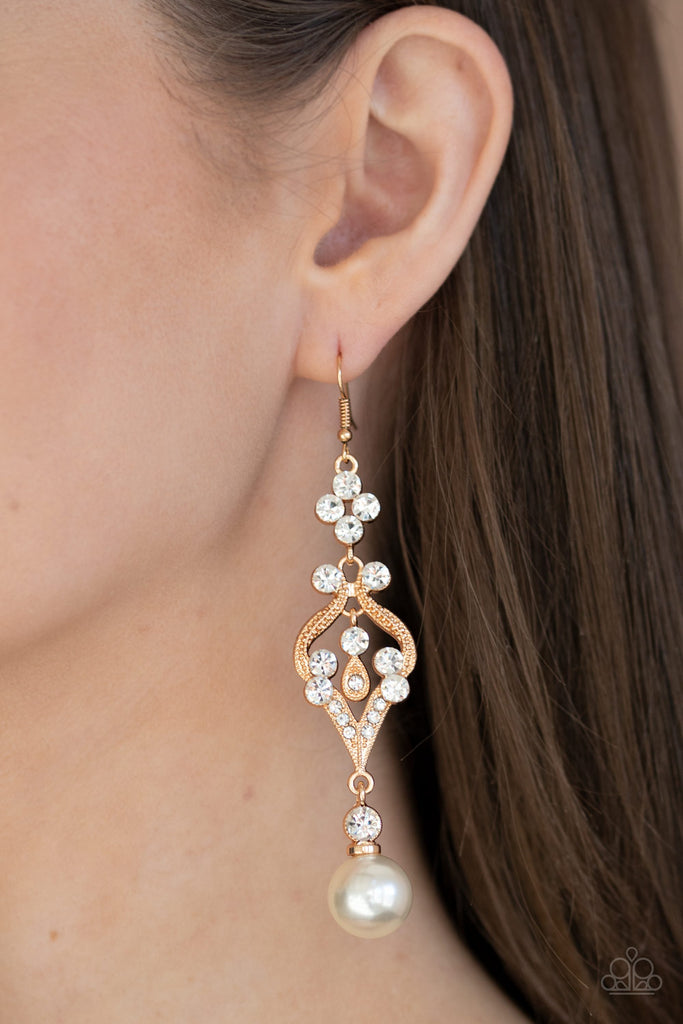 paparazzi earrings An oversized white pearl dangles from the bottom of a flowery gold frame dotted in sections of glassy white rhinestones for an elegant look. Earring attaches to a standard fishhook fitting.  Sold as one pair of earrings.